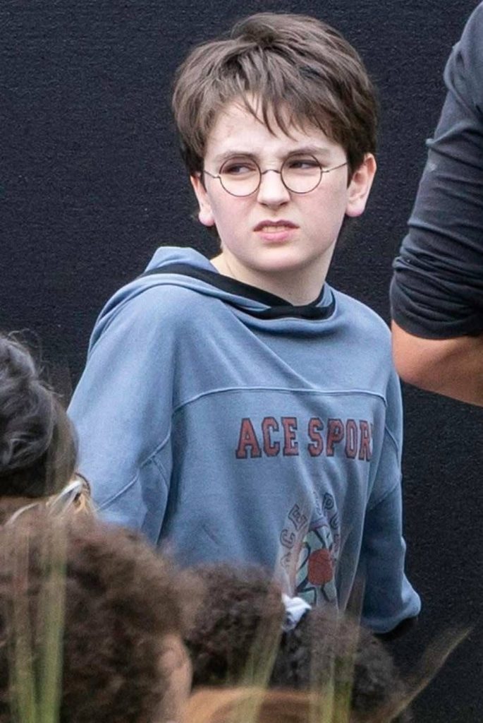 Chlapec z okuliarmi a modrou mikonou a typickým výrazom ako Harry Potter z knižnej predlohy.